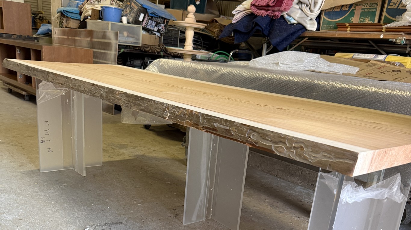 素材となる杉の一枚板と透明なアクリル脚