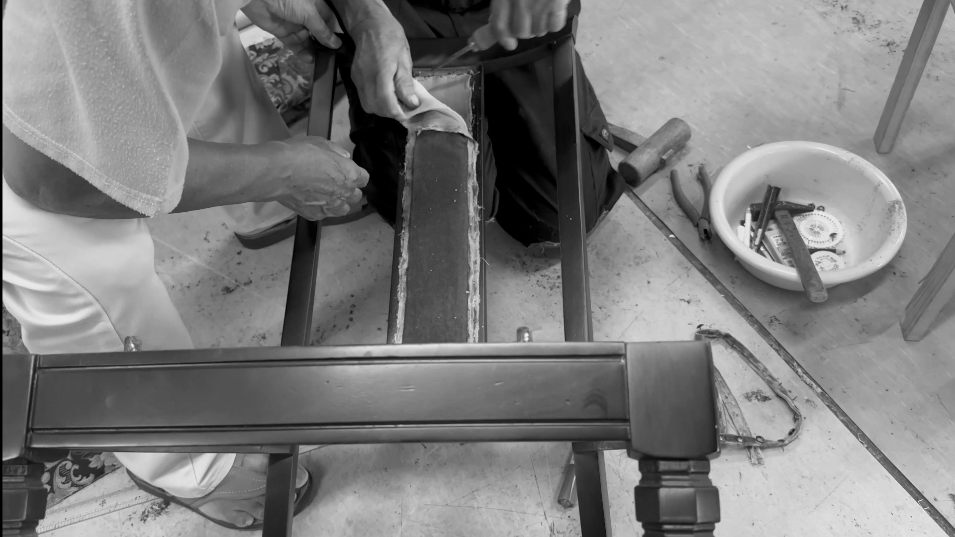 椅子の背を丁寧に剥がす作業を行う職人の画像